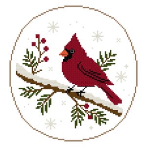May include: A circular cross-stitch pattern featuring a vibrant red cardinal bird perched on a brown branch covered in white snow. The design includes dark green pine needles, small red berries, and light gray snowflakes on a white background.
