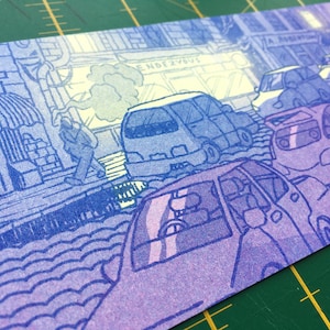 May include: A blue and purple illustration of a city street scene with cars and a pedestrian walking past a shop with the word "Rendezvous" above the entrance.