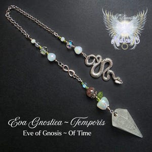 May include: A silver-toned pendulum with a chain, beads, and a crystal point. The design includes a snake charm, an infinity symbol, and the text "Eva Gnostica ~ Temporis" and "Eve of Gnosis ~ Of Time". The pendulum has a spiritual or metaphysical theme.