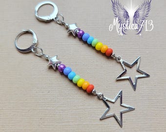 May include: A pair of rainbow star earrings with silver star charms and silver hooks. The earrings are made with colourful beads and feature a rainbow colour scheme.