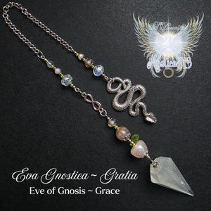 May include: A silver-toned pendulum with a snake charm, infinity symbol, and crystal beads. The pendulum has a clear, pointed crystal at the end. The text "Eva Gnostica ~ Gratia" and "Eve of Gnosis ~ Grace" are visible.
