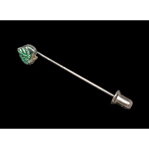 Puede incluir: Pin de solapa plateado con una cabeza en forma de hoja. El diseño de la hoja presenta detalles verdes y plateados. El pin tiene un eje largo y delgado y una parte trasera redondeada. El fondo es negro.