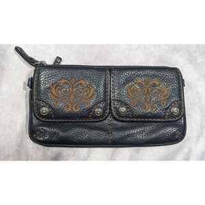 May include: Black leather wallet with two front pockets and brown embroidered floral designs. The wallet has a zipper closure and silver studs.