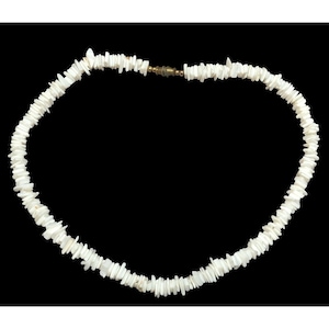 Puede incluir: Collar de chips blancos con cierre dorado. El collar está hecho de pequeños chips blancos de forma irregular ensartados. El fondo es negro, lo que resalta el color blanco brillante del collar.