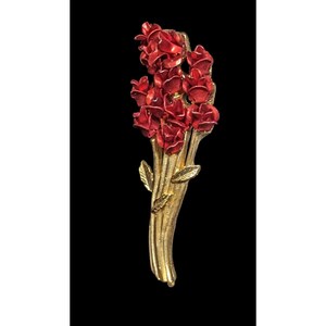 Puede incluir: Broche vintage dorado con un ramo de rosas rojas. Las rosas tienen pétalos detallados y un acabado brillante. Los tallos y las hojas son dorados, creando un contraste con las rosas rojas. Un accesorio floral clásico.