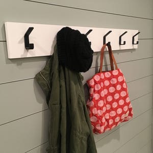 Modern simple coat hooks mounted to board in bathroom