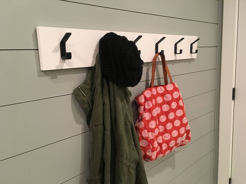 Modern simple coat hooks mounted to board in bathroom