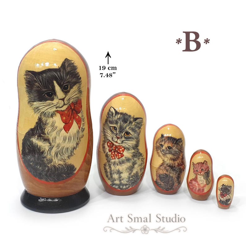 Black and white kitten painted on the largest Russian nesting doll, accompanied by four matching hand painted wooden Matryoshka dolls on a clean white background with size reference