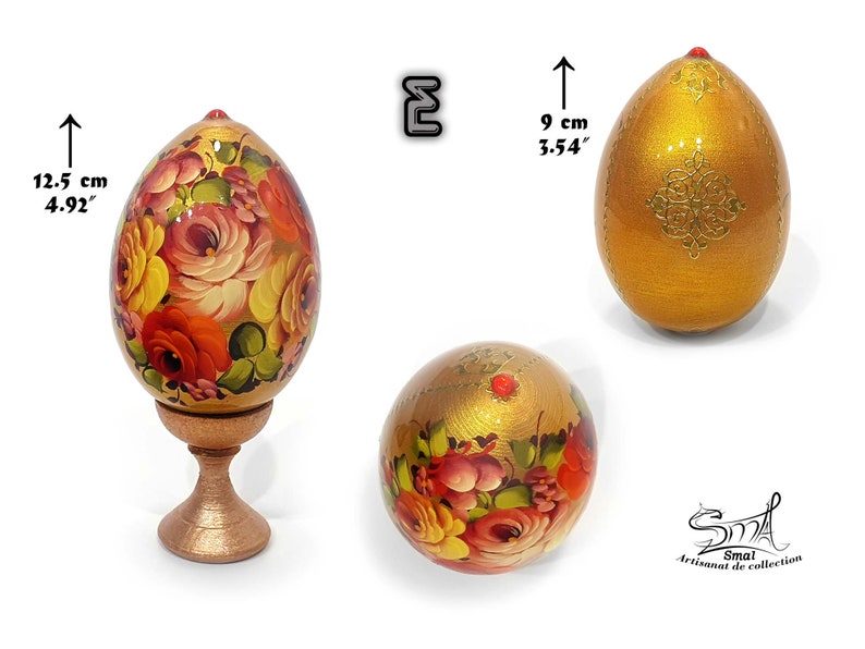 Œuf de Pâques or lumineux au fini nacré, décor floral peint à la main dans l’esprit de l’art russe, enrichi de motifs dorés et d’un cabochon rouge, présenté sur socle, hauteur totale 12,5 cm, hauteur de l’œuf 9 cm