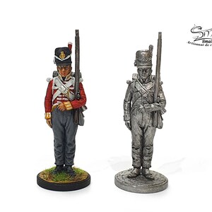 May include: Two painted miniature figures of British soldiers from the Napoleonic Wars. The figure on the left is painted in red, white, and blue, while the figure on the right is painted in silver. Both figures are holding muskets and are standing on circular bases.