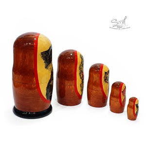 Angled side view of hand painted Russian nesting dolls highlighting the smooth curved silhouette, natural wood grain, glossy lacquer finish, and traditional Matryoshka craftsmanship from largest to smallest