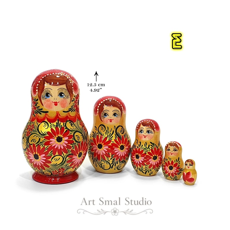 Variante E : matriochka russe aux tons jaune doré nacré, ornée de fleurs rouges et roses peintes à la main. Ensemble de cinq poupées en bois inspiré de l'art traditionnel russe, création artisanale de la collection Zoia.