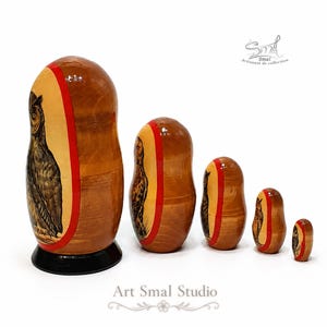 Side view of a Russian nesting doll set with five hand-painted owls, arranged from the largest to the smallest. The owls are visible along the left side of each wooden doll, with natural wood backs, red painted borders, glossy varnish, and the largest doll standing on a black base. The set is photographed against a clean white background