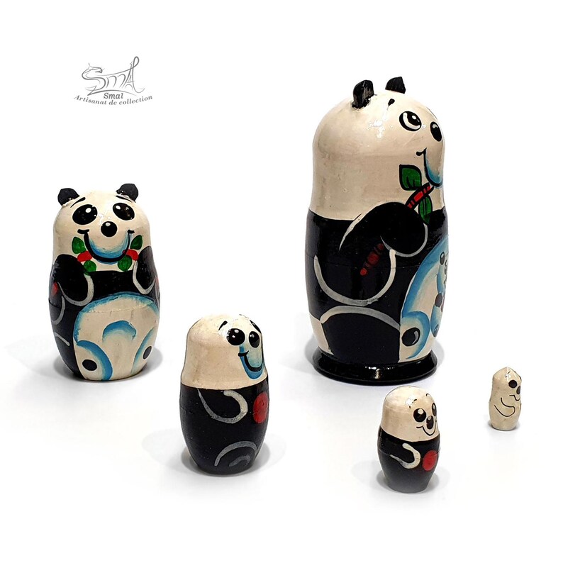 Side view of a five-piece panda matryoshka nesting doll set, showing the hand-painted Russian wooden dolls from different angles with their black, white, blue, green and red decorative details.