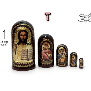 A set of five Russian religious matryoshka dolls. The largest doll, 11 cm (4.33 inches) tall, features an icon of Jesus Christ, while the four smaller nesting dolls are adorned with various other Orthodox icons.