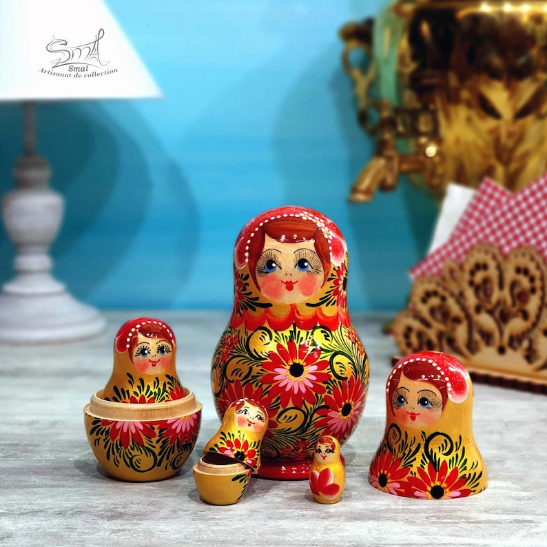 Poupée russe Matriochka ouverte montrant les cinq figurines emboîtables de la collection Zoia. Artisanat en bois peint à la main, décor floral rouge et jaune doré nacré, idéal pour les collectionneurs et la décoration intérieure.