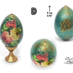 Œuf de Pâques décoratif aux inspirations russes, teinte verte nacrée, orné d’une composition florale réalisée à la main et de motifs dorés avec cabochon, présenté avec son socle, hauteur totale 12,5 cm, hauteur de l’œuf 9 cm