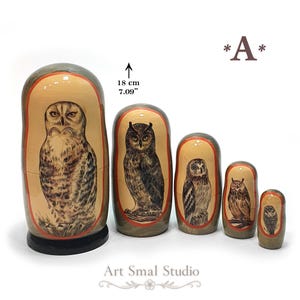Owls hand-painted on five Russian nesting dolls, featuring different owl species with detailed feathers and natural brown, gray, and beige tones. The 18 cm Matryoshka set is displayed against a clean white background, with the five dolls arranged from largest to smallest