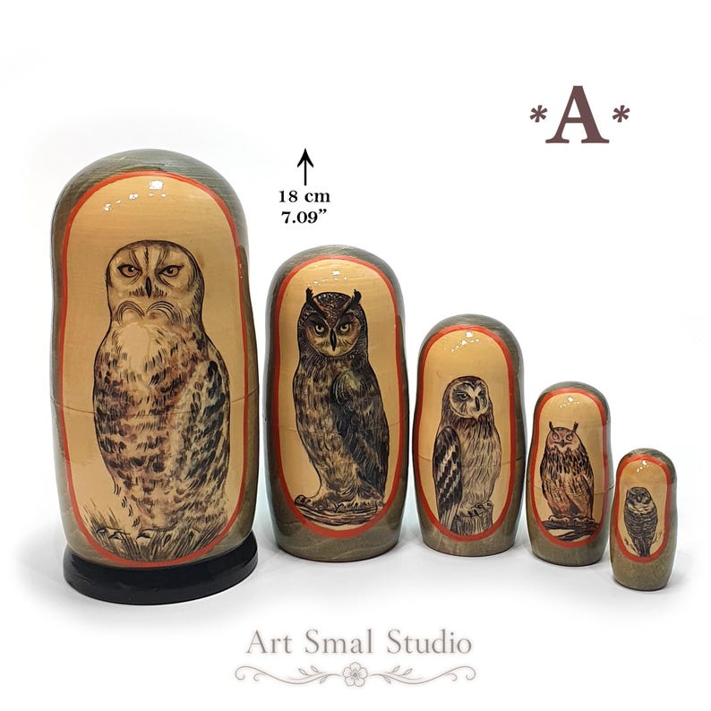Owls hand-painted on five Russian nesting dolls, featuring different owl species with detailed feathers and natural brown, gray, and beige tones. The 18 cm Matryoshka set is displayed against a clean white background, with the five dolls arranged from largest to smallest