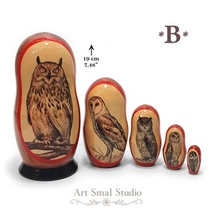 Owls hand-painted on a set of five Russian nesting dolls, featuring different owl species including a large horned owl, a barn owl, and smaller owls in natural brown and beige tones. The 19 cm Matryoshka set is arranged from largest to smallest against a clean white background