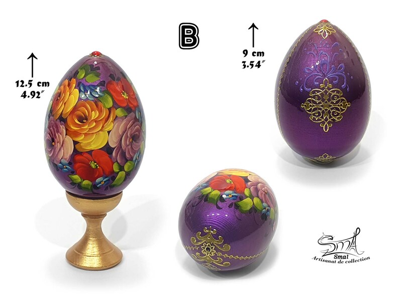 Œuf décoratif de Pâques en style russe, surface violette irisée, composition florale peinte à la main, rehaussée d’ornements dorés et d’un détail bijou, présenté sur socle, hauteur totale 12,5 cm, œuf seul 9 cm