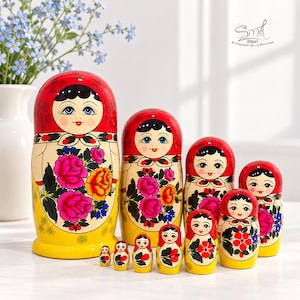 May include: A set of ten wooden nesting dolls featuring hand-painted floral designs with bright red, yellow, and green colours. Each doll depicts a figure with a red headscarf, black hair, and blue eyes, decorated with vibrant pink and orange roses.