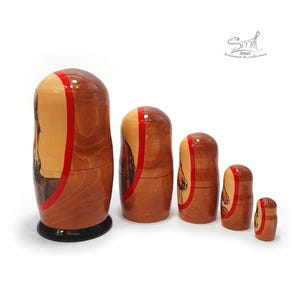 Left side view of five horse-themed wooden nesting dolls, highlighting their smooth wood grain, red decorative bands, different sizes, and hand painted equestrian artwork