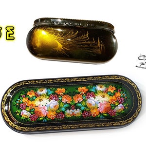 Puede incluir: Dos cajas ovaladas de laca negra con detalles dorados. La caja m&aacute;s peque&ntilde;a tiene un fondo dorado con un dise&ntilde;o de pluma de pavo real. La caja m&aacute;s grande tiene un fondo verde con un dise&ntilde;o floral. Ambas cajas est&aacute;n decoradas con bordes dorados.