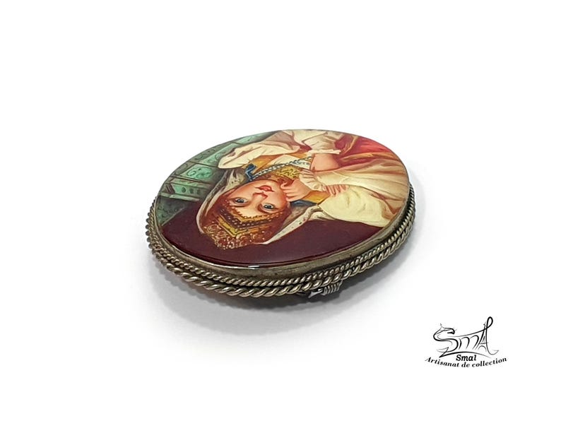 Broche de collection russe – femme en habit traditionnel peinte à la main sur nacre, finition vernie brillante.