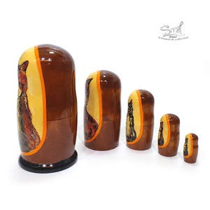 Side view of hand painted Russian nesting dolls showing the curved wooden shape, glossy lacquer finish, and traditional Matryoshka craftsmanship arranged from largest to smallest