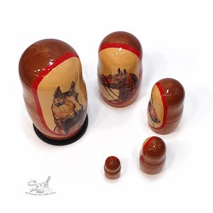 Overhead view of a five-piece horse nesting doll set, highlighting the glossy wood finish, hand painted horse portraits, red accents, and unique arrangement of each Russian matryoshka