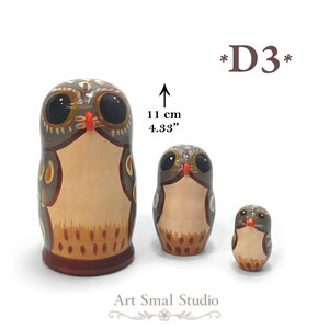 May include: Three nesting owl figurines painted in shades of brown, gray, and cream with large black eyes and orange beaks. The largest owl is 4.33 inches tall. The text *D3* appears in the upper right, and Art Smal Studio is at the bottom.