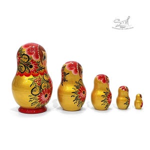 Vue latérale droite de la matriochka russe jaune doré nacrée. Les cinq poupées gigognes en bois révèlent la richesse des motifs floraux peints à la main qui se prolongent harmonieusement sur les côtés.
