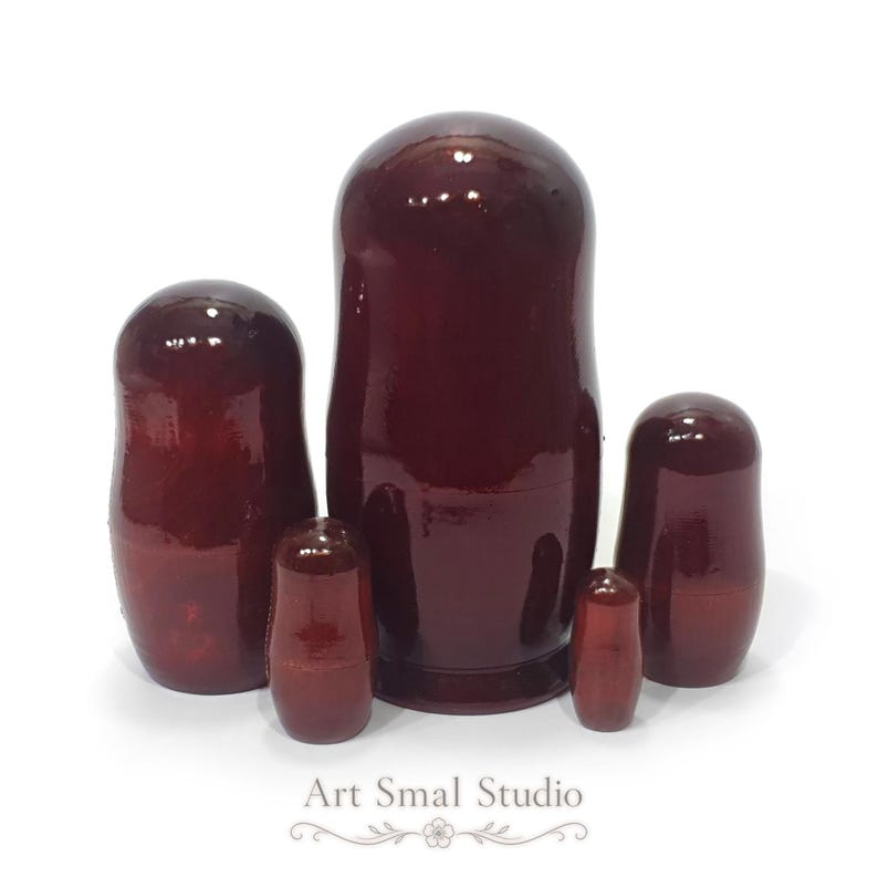 Back view of a hand-painted Russian Orthodox nesting doll set of 5, showing the glossy lacquered reverse side of traditional wooden Matryoshka dolls arranged from largest to smallest on a white background.
