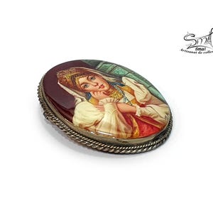Bijou artisanal russe – peinture miniature d'une femme folklorique sur nacre, art traditionnel.
