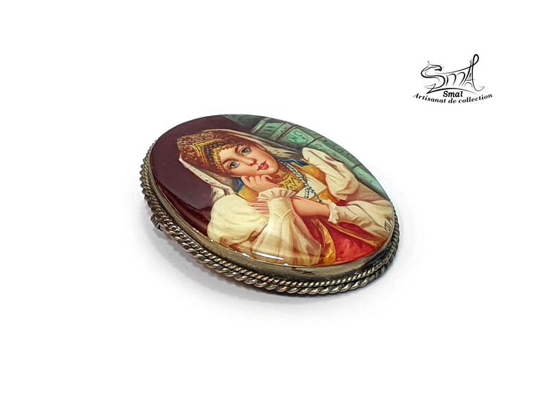 Bijou artisanal russe – peinture miniature d'une femme folklorique sur nacre, art traditionnel.