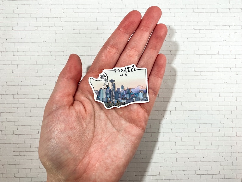 May include: A sticker depicting the Seattle skyline with the Space Needle, mountains, and the text "Seattle WA."