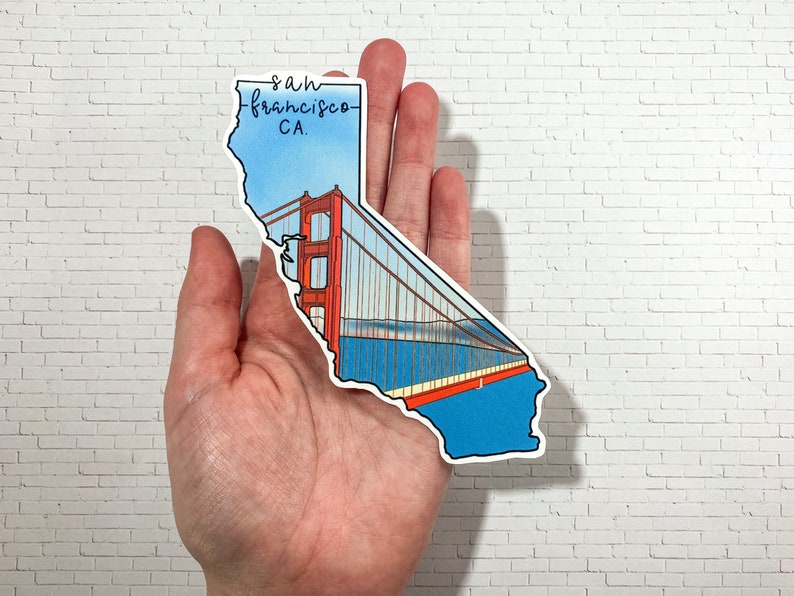 Op de afbeelding: Een sticker in de vorm van de staat Californi&euml; met de Golden Gate Bridge en de tekst "san francisco CA." erop gedrukt.