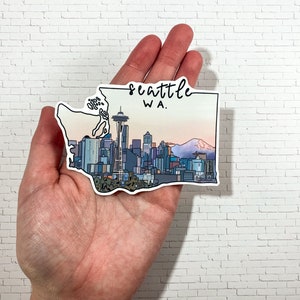 May include: A sticker of the Seattle skyline with the Space Needle, Mount Rainier, and the text "Seattle WA."