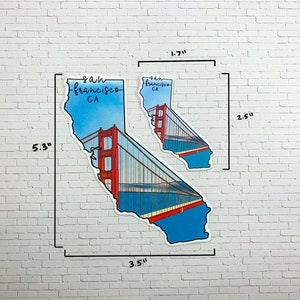Op de afbeelding: Een sticker van de Golden Gate Bridge in de vorm van de staat Californi&euml;. De sticker is 8,9 cm breed en 13,5 cm hoog. De sticker is blauw, rood en wit. De tekst "San Francisco, CA." staat op de sticker.