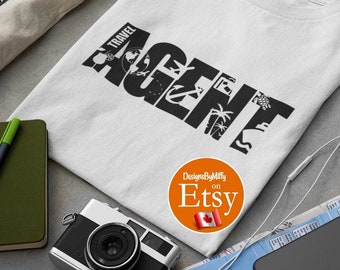May include: White t-shirt with the words "TRAVEL AGENT" in a black, stylized font. The design incorporates travel-related imagery. The shirt is surrounded by travel accessories, including a camera, sunglasses, and a map.