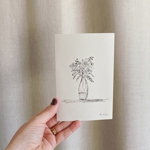May include: A black and white line drawing of a bouquet of flowers in a vase. The drawing is signed "K.Hem".