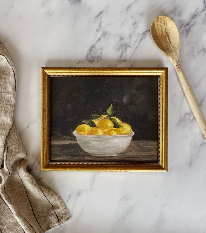 May include: A framed painting of a white bowl filled with yellow lemons on a dark background.