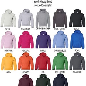 Puede incluir: Una carta de colores de sudaderas con capucha Gildan Youth Heavy Blend que muestra quince sudaderas de manga larga con bolsillos delanteros en varios colores, incluyendo blanco, gris, grafito, negro, rosa, fucsia, morado, azul, oro, naranja, rojo, verde, carb&oacute;n, granate, bosque y marino.
