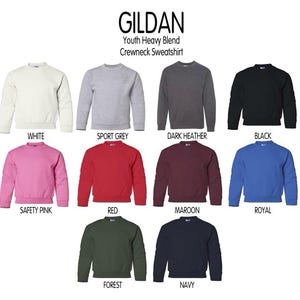 Puede incluir: Una colecci&oacute;n de sudaderas de cuello redondo Gildan Youth Heavy Blend mostradas en diez colores diferentes, incluyendo blanco, gris deportivo, gris oscuro, negro, rosa ne&oacute;n, rojo, granate, azul real, verde bosque y azul marino, con mangas largas.