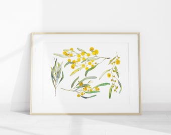 May include: Watercolor print of mimosa branches with yellow flowers and green leaves. The artwork is framed in a gold-colored frame and set against a white background. The botanical illustration is a decorative piece.