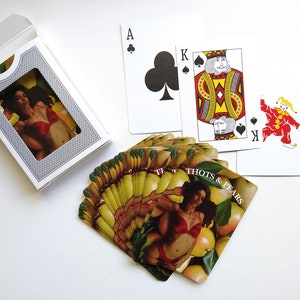 May include: A deck of playing cards with a woman in a red bra and a pear design on the back of the cards. The cards are fanned out and the text on the back of the cards reads "Thots & Pears".