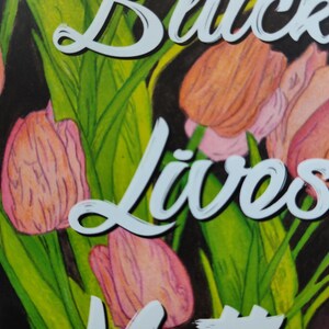 May include: A watercolour painting of tulips in shades of pink and orange, with green leaves. The words "Black Lives" are written in white script across the image. The background is dark.