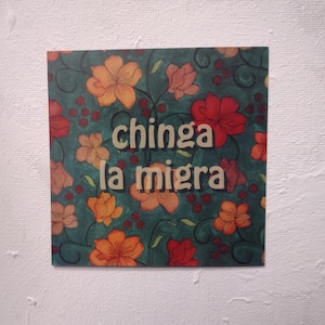 Puede incluir: Un fondo azul verdoso con un patr&oacute;n floral con flores naranjas, rojas y blancas. El texto "chinga la migra" est&aacute; escrito en letras blancas.