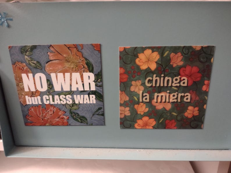 Puede incluir: Dos imanes cuadrados con patrones florales y texto blanco en negrita. El im&aacute;n de la izquierda dice "NO WAR but CLASS WAR". El im&aacute;n de la derecha dice "chinga la migra".